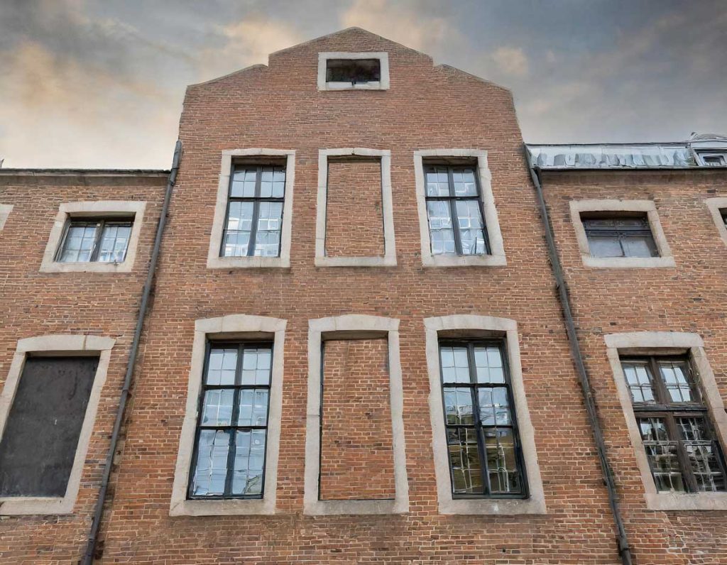 a-building-with-a-mix-of-real-windows-and-what-appear-to-be-bricked-up-windows
